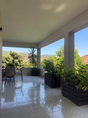 a balcony with a table and chairs and plants at Vila Culli in Përmet