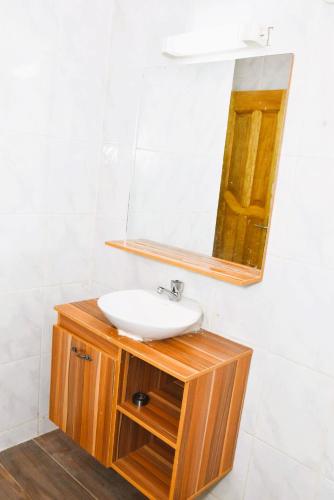 a bathroom with a sink and a mirror at Cosy by dalyda in Yaoundé