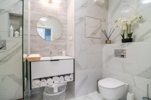 a bathroom with a toilet and a sink and a mirror at Modern beautiful apartment close to the center in Bratislava
