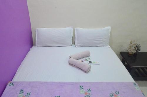 a bed with two rolled up towels on it at Hamsa Home Stay in Hampi