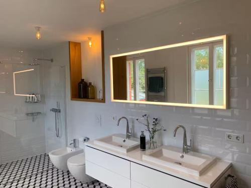 ein Badezimmer mit zwei Waschbecken und einer Toilette und einem Spiegel in der Unterkunft Landidyll - Bauernhaus Ländchen Bellin 
