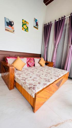 a bed in a room with purple curtains at RKS- The Studio Farm in Valap