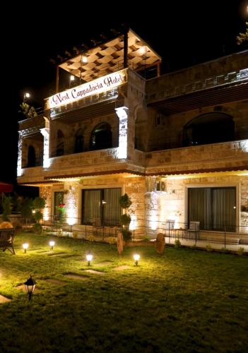 a large stone building with lights in the grass at Nest Cappadocia Hotel in Uchisar