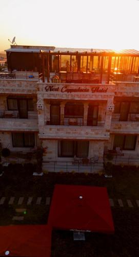a large white building with a red roof at Nest Cappadocia Hotel in Uchisar