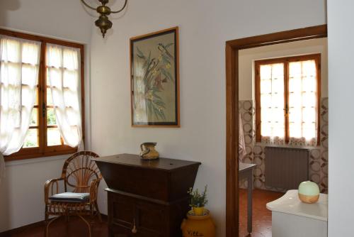 a living room with a dresser and two windows at Villa Panorama Exclusive Pool in Loro Ciuffenna