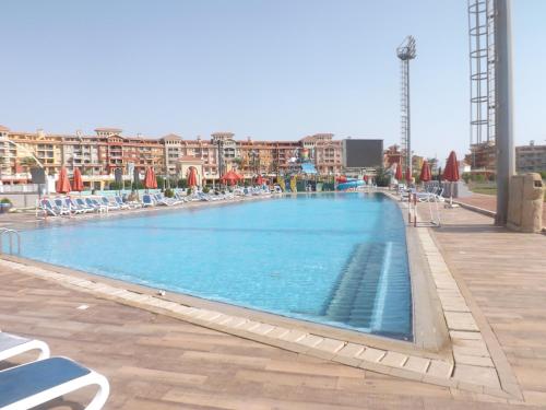 a large swimming pool with chairs and umbrellas at Porto Sharm Retreat by Mraky Rentals in Sharm El Sheikh