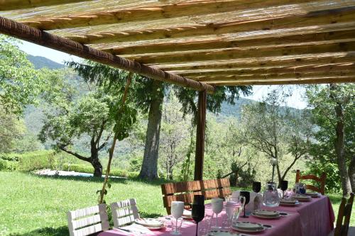 a table with a purple tablecloth and chairs under a pergola at Villa Panorama Exclusive Pool in Loro Ciuffenna