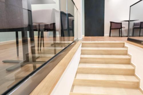 a staircase in a house with glass and wood at The MONT BOUTIQUE HOTEL in Shkodër