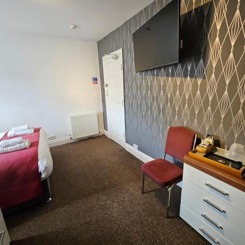a bedroom with a bed and a desk and a chair at Rose-Dene in Scarborough