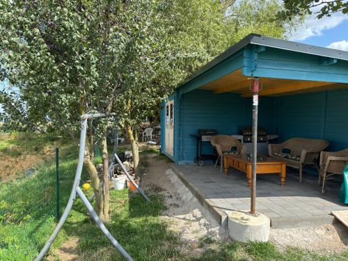 a blue shed with a table and chairs in a yard at Mein alter Bauernhof Strassburgerhof in Welling