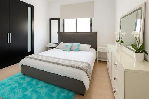 a bedroom with a large bed with a blue rug at Blue Tulip - Strovolos in Kato Lakatamia