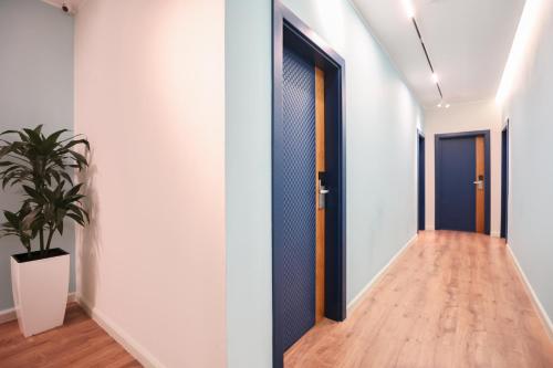 a hallway with a door and a potted plant at The MONT BOUTIQUE HOTEL in Shkodër