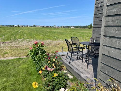 a patio with chairs and a table and flowers at Blossombed in Voorhout