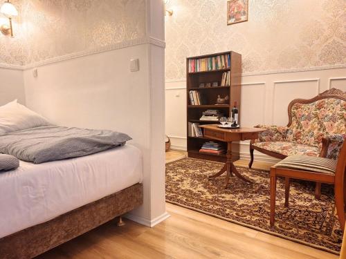 a bedroom with a bed and a chair and a table at Prime Location Luxury Flat in Karlovy Vary