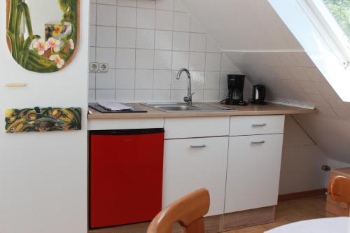 a kitchen with a sink and a red refrigerator at Rittergut Haus Laer in Bochum