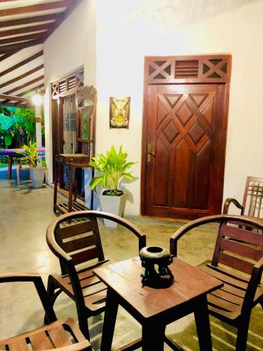 a room with chairs and a table and a wooden door at Coco Grove in Galle