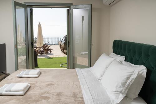 a bedroom with a bed with a green headboard at THISEFS luxury apartments Kefalonia in Antipata