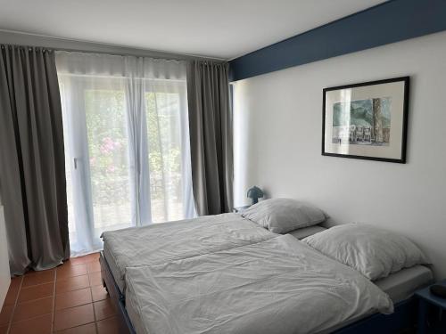 a bed in a bedroom with a large window at Havelhaus Werder in Glindow