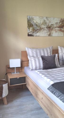 a bedroom with a bed and a nightstand with a lamp at City-Appartement Pirna in Pirna