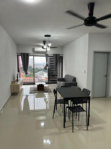 a living room with a table and chairs and a ceiling fan at Cozy Condo Admiral Residences Melaka in Melaka