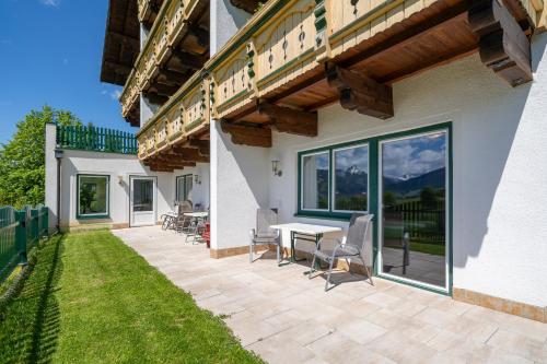 a patio with a table and chairs next to a building at Aparthotel Sunrise in Ramsau am Dachstein