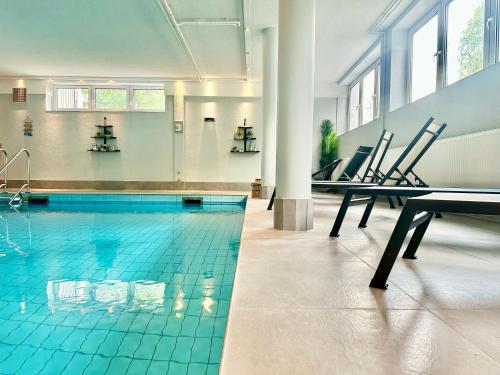 a swimming pool with blue tiles on the floor at Beachside Grömitz - 21 Apartments, Pool & Sauna direkt am Meer in Grömitz