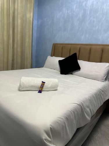 a large white bed with two pillows and aigilvisor on it at Modern and cozy apartment in Lusaka