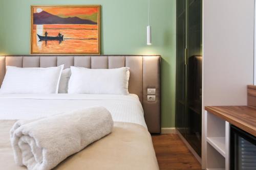 a bedroom with a bed and a painting on the wall at The MONT BOUTIQUE HOTEL in Shkodër