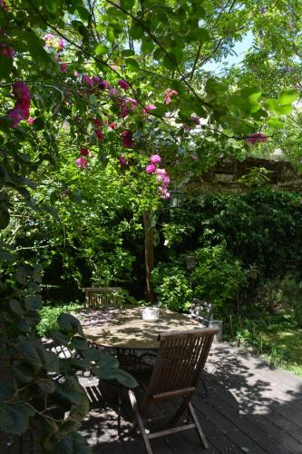 a wooden chair sitting on a patio under a tree at la maison in Libourne