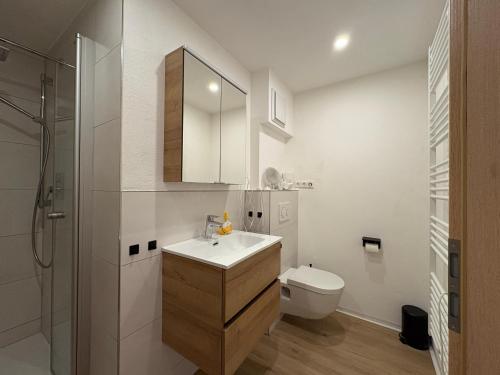 a white bathroom with a sink and a toilet at Oetztal Auszeit Top 7 in Umhausen