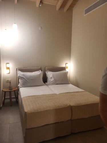 a bedroom with a bed with white sheets and pillows at villas cape in Plateies