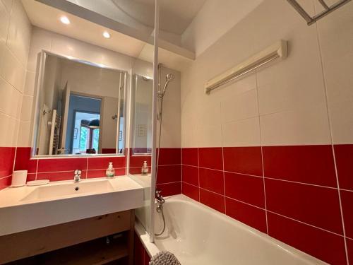 un bagno con un lavandino, una vasca e uno specchio di Appartement Le Cerf- T2 sur front de neige - LA TANIA a Courchevel