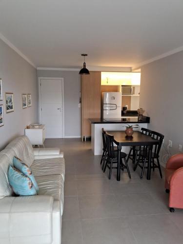 a living room with a white couch and a table at Apartamento novo entre a praia dos Ingleses e Santinho in Florianópolis