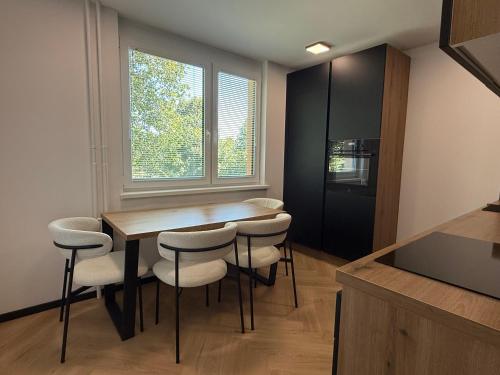 a kitchen with a table and chairs and a window at Moderno stanovanje - Ptuj in Ptuj