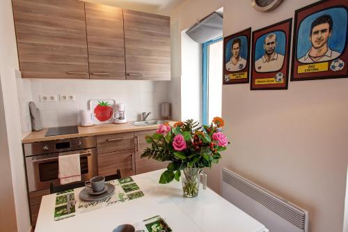une cuisine avec un vase de fleurs sur une table dans l'établissement Studio Panier 2000, à Marseille