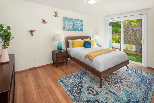 ein Schlafzimmer mit einem Bett und einem großen Fenster in der Unterkunft Mid century modern air conditioned retreat with expansive garden in Lake Forest Park