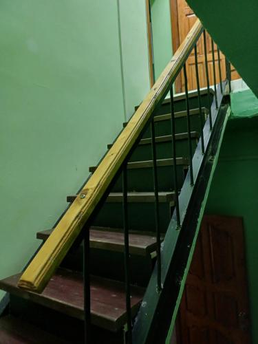 a set of stairs in a building with a wooden railing at Econom house in Naryn