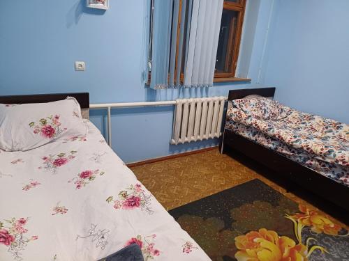 a bedroom with two beds and a window at Econom house in Naryn