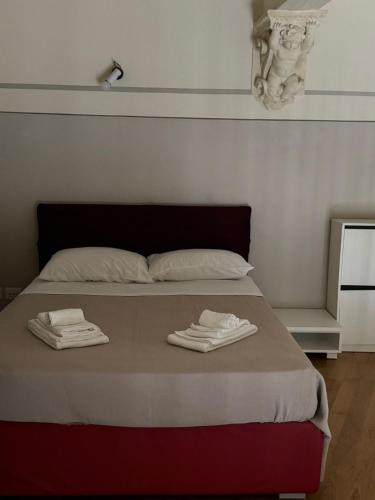 a bed with two towels on top of it at Loft Termini in Siena