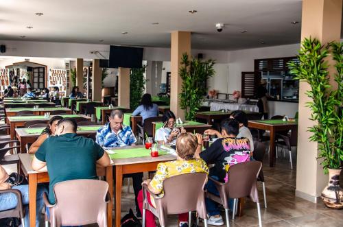 a group of people sitting at tables in a restaurant at Hotel Abadias De Zapatoca in Zapatoca