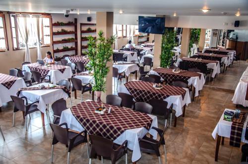 a restaurant with tables and chairs and people sitting at them at Hotel Abadias De Zapatoca in Zapatoca