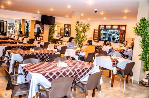 a restaurant with tables and chairs and people sitting in it at Hotel Abadias De Zapatoca in Zapatoca