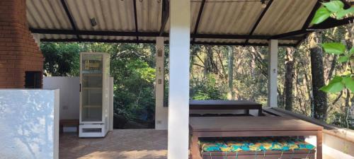 a porch with a wooden bench and a door at Chalé com clima de montanha em Mairiporã in Mairiporã