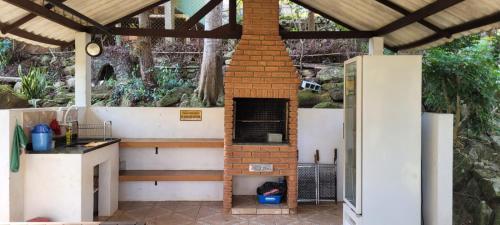 an outdoor kitchen with a brick oven in a patio at Chalé com clima de montanha em Mairiporã in Mairiporã