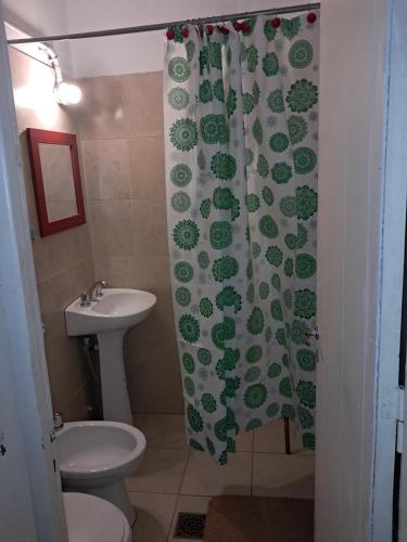 a bathroom with a sink and a toilet and a shower curtain at El Colibrí de centro1 in Capilla del Monte