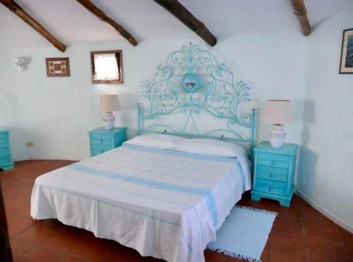 a bedroom with a bed and two blue night stands at Villa Degli Artisti in Cugnana