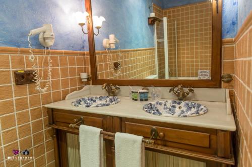 a bathroom with two sinks and a mirror at Masía De Lacy in Museros