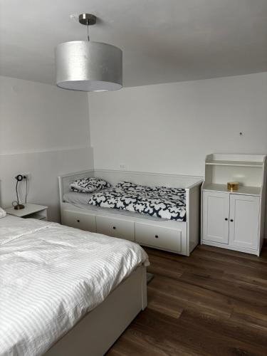 a white bedroom with two beds and a lamp at Kraljev Vrh Apartments in Kraljev Vrh
