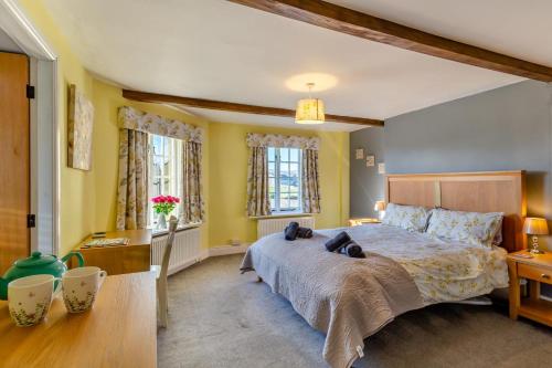 Un dormitorio con una cama grande y dos ventanas. en Ellesmere House, en Grassington