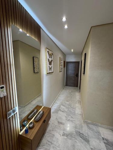 马拉喀什Résidence Soulaymane اقامة سليمان的一间设有走廊、桌子和镜子的客房